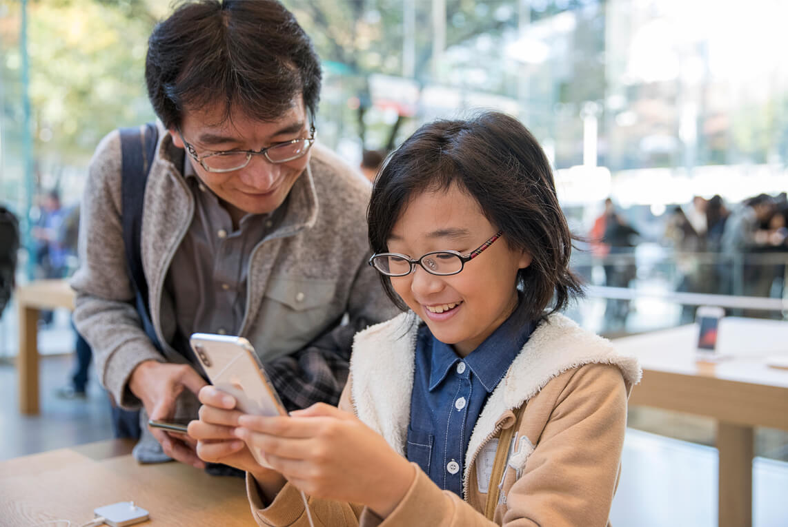 iPhoneXを触る子供の写真